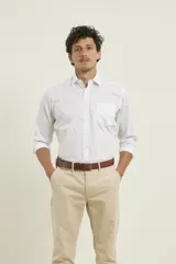 Camisa de vestir blanca de manga larga con cuello clásico, cierre frontal de botones y bolsillo en el pecho.