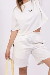 Bermuda blanca de corte holgado con cintura elástica y largo hasta la rodilla.