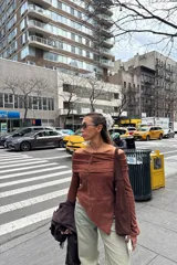 Remera color marrón con textura acanalada, corte asimétrico y hombros descubiertos.