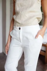 Pantalón de tiro alto con pierna levemente acampanada, confeccionado en lino. Presenta diseño clásico con pinzas delanteras y cierre frontal.