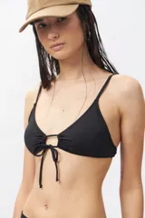 Top de bikini blanco con escote halter, abertura circular en el centro y lazos ajustables.