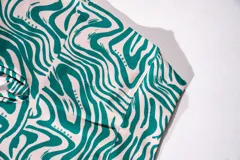 Calza biker deportiva con estampado abstracto en tonos verde y blanco.