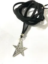 Collar con cordón de cuero negro y dije de estrella plateada con pequeñas estrellas caladas.