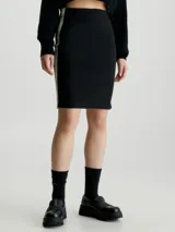 Falda corta negra de tejido acanalado, corte slim y cintura elástica. Presenta una cinta con logo en el lateral izquierdo en tonos verde y negro.