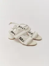 Sandalias de tacón bajo y redondo, con diseño de tiras finas en gamuza y paneles laterales de material translúcido. Cuentan con cierre de pulsera ajustable al tobillo.