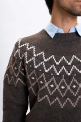 Buzo de tejido de punto en color marrón con diseño jacquard geométrico en la parte superior del pecho y hombros. Presenta cuello redondo, mangas largas y puños acanalados.