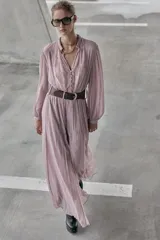 Vestido midi de color rosado con escote en pico y mangas largas. Presenta un diseño combinado con paneles de encaje en el frente y cierre frontal con botones forrados. Incluye un cinturón de cuero sintético marrón con hebilla metálica dorada.