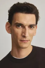 Buzo de punto fino color marrón oscuro, con cuello redondo y remates acanalados en cuello, puños y bajo.