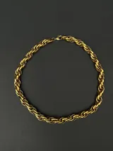 Collar de cadena con eslabones trenzados de diseño robusto y versátil. Fabricado en acero inoxidable con recubrimiento en tono dorado.