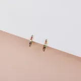 Par de aros dorados tipo argolla con incrustaciones de cristales de colores. Fabricados en acero con baño de oro de 18k y cristales Cubic Zirconia.