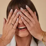 Anillo doble en oro 18k, compuesto por una alianza fina con engaste de brillantes y una alianza lisa con un brillante central.