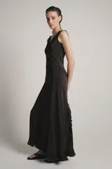 Vestido largo de viscosa en color negro, con escote redondo y tirantes anchos con detalle de volados. Presenta bordados florales a tono en la parte superior y bajo con terminación evasé.