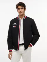 Campera estilo bomber de Tommy Hilfiger en colaboración con Cadillac Formula 1® Team, color negro. Cuenta con cuello tipo béisbol, cierre frontal de cremallera y ribetes tejidos a rayas rojas, blancas y azules en el cuello, puños y dobladillo. Presenta parches bordados del equipo en el pecho.