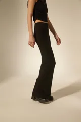 Pantalón tipo calza de tiro alto con corte flare, confeccionado en tejido de viscosa y elastano con detalles de strass dispersos.