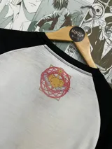 Remera blanca con mangas raglán negras y estampado de Kero Chan de Sakura Card Captor.