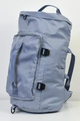 Bolso mochila azul grisáceo con múltiples bolsillos y correas ajustables.
