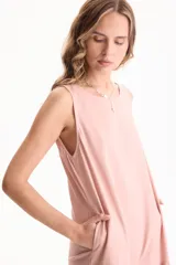 Vestido largo negro de lino, sin mangas, con escote redondo y diseño fluido con volados escalonados en la falda.