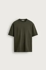 Remera de corte relaxed fit confeccionada en tejido de algodón con textura irregular, cuello redondo y manga corta.