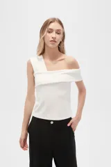 Top blanco de poliéster, al cuerpo, con bretel ancho y cuello asimétrico.