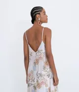 Vestido midi de viscosa con estampado floral en tonos pastel. Presenta escote en V, tirantes delgados ajustables y bajo asimétrico con puntas.
