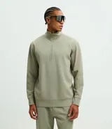 Buzo de cuello alto con cierre frontal parcial, manga larga y puños ajustados. Presenta un diseño minimalista en color verde militar.