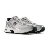 Championes New Balance modelo 509, de color plateado y blanco con detalles en negro, diseño de inspiración retro con capellada de malla transpirable, suela con tecnología ABZORB y cierre de cordones.