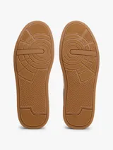 Zapatillas de tenis Tommy Hilfiger de corte bajo, confeccionadas en piel nobuk con paneles de texturas mixtas en blanco y gris. Presentan suela de goma color caramelo, cierre con cordones y detalles distintivos de la marca en la lengüeta, lateral y talón.