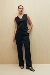 Pantalón negro de corte recto y tela liviana con brillo metalizado.