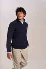 Sweater de punto acanalado color azul marino, con cuello alto y cierre frontal parcial. Presenta el logo de la marca bordado en el pecho y puños con terminación elástica.