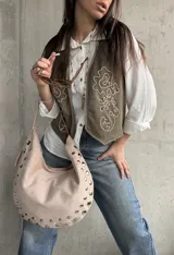 Chaleco verde militar de gamuza, con bordados en hilo crudo, diseño de flores y detalles de tachas metálicas.