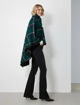 Capa de tejido cuadrille con diseño de cuadros en tonos marrón, beige y naranja. Presenta un cierre frontal con botón tipo trenca y bordes con ribete negro.