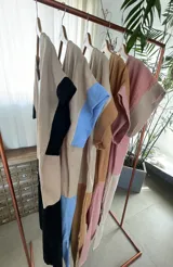 Vestido largo estilo túnica de algodón con diseño bicolor, cuerpo en tono tostado y parte inferior negra, de manga corta y cuello redondo.