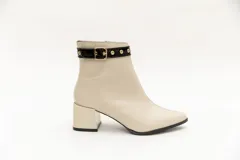 Botas de cuero negro, de caña baja, punta fina y taco cuadrado. Presentan un aplique charolado al tono, una correa con hebilla y ojales metálicos.