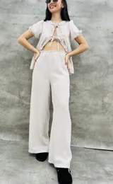 Pantalón palazzo color beige con finas rayas verticales blancas y cintura elastizada.