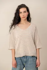 Sweater de tejido de punto a rayas horizontales en tonos beige y blanco, con escote en V y mangas cortas holgadas.