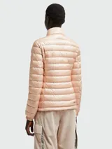 Chaqueta acolchada color rosa pálido con cierre frontal de cremallera, cuello alto y bolsillos laterales con cremallera.