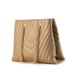 Cartera tipo tote de diseño acolchado en color taupe, confeccionada en símil cuero. Presenta costuras decorativas en forma de V, doble asa de cadena metálica dorada y una correa larga regulable y extraíble. Incluye cierre principal y logo de la marca grabado en el frente.