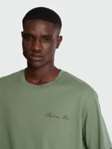 Remera de corte holgado en color blanco, con cuello redondo y mangas cortas. Presenta un bordado discreto con la firma de Balmain en el pecho.