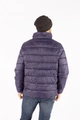 Campera puffer de invierno color azul marino, con cuello elevado, cierre frontal completo y capucha oculta. Presenta bolsillos laterales con cierre y logo en relieve en el pecho.