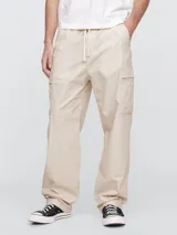 Pantalón cargo de corte holgado, confeccionado en popelina color beige, con cintura elástica ajustable mediante cordón y bolsillos laterales tipo cargo.