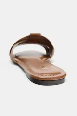 Sandalias planas de piel color marrón, con diseño de tiras cruzadas en la parte delantera y suela baja.