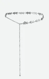 Cinturón de cadena plateada con dijes en forma de estrellas y cadena colgante lateral.