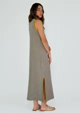 Vestido midi de punto con diseño a rayas verticales en tonos mostaza y blanco, con cuello redondo y sisas contrastadas en color bordó. Presenta aberturas laterales en el ruedo con detalles en color bordó.