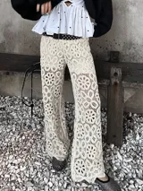Pantalón de crochet color crudo, de tiro alto y corte acampanado, con diseño de flores caladas.