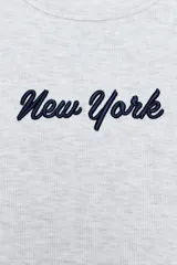 Musculosa de canalé gris claro melange, de corte ajustado, con cuello redondo y texto bordado en contraste en el pecho.