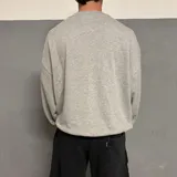 Buzo gris de corte oversize con cuello redondo y puños y cintura acanalados. Estampado frontal con la palabra "Midway" en blanco con borde negro. Tiene bolsillo tipo canguro.