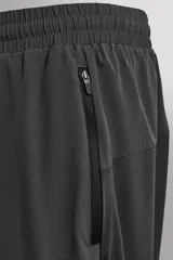Pantalón negro de entrenamiento slim fit confeccionado en tejido técnico ligero y elástico con estructura. Cuenta con cintura elástica ajustable con cordón, bolsillos frontales y trasero con cierre de cremallera, y bajo ajustable con cremallera en laterales.