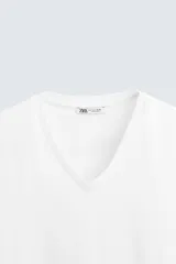 Camiseta blanca de algodón con elasticidad, corte slim fit, cuello en V y mangas cortas.
