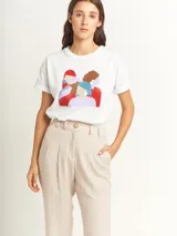 Remera blanca de corte oversized con estampado de figuras femeninas abstractas en colores rojo, marrón, celeste y lila.