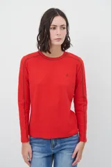 Remera de manga larga color rojo, con costuras decorativas en contraste a lo largo de las mangas y logo bordado pequeño en el pecho.